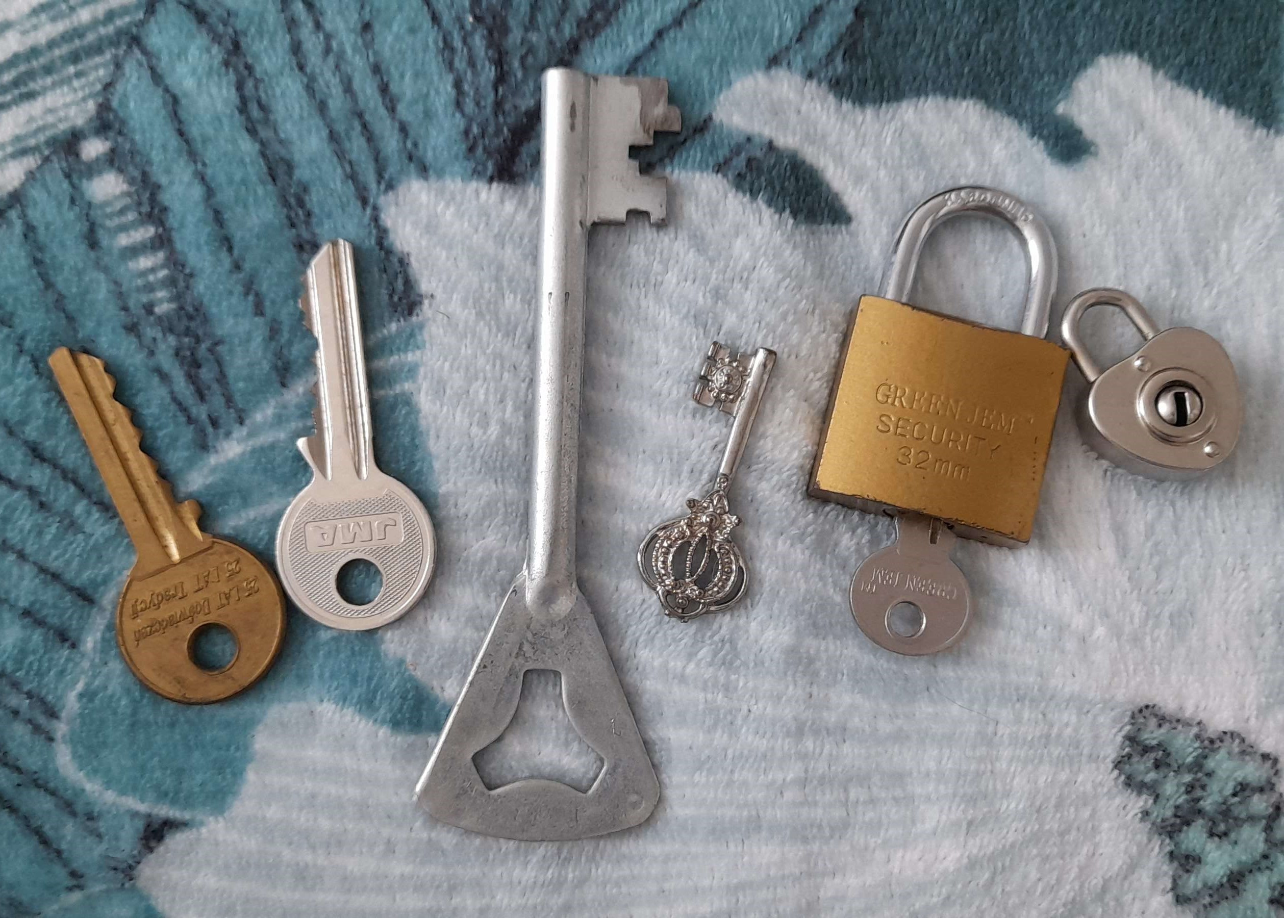 an image of four keys and two padlocks. all the keys are different sizes and colours, same with the padlocks