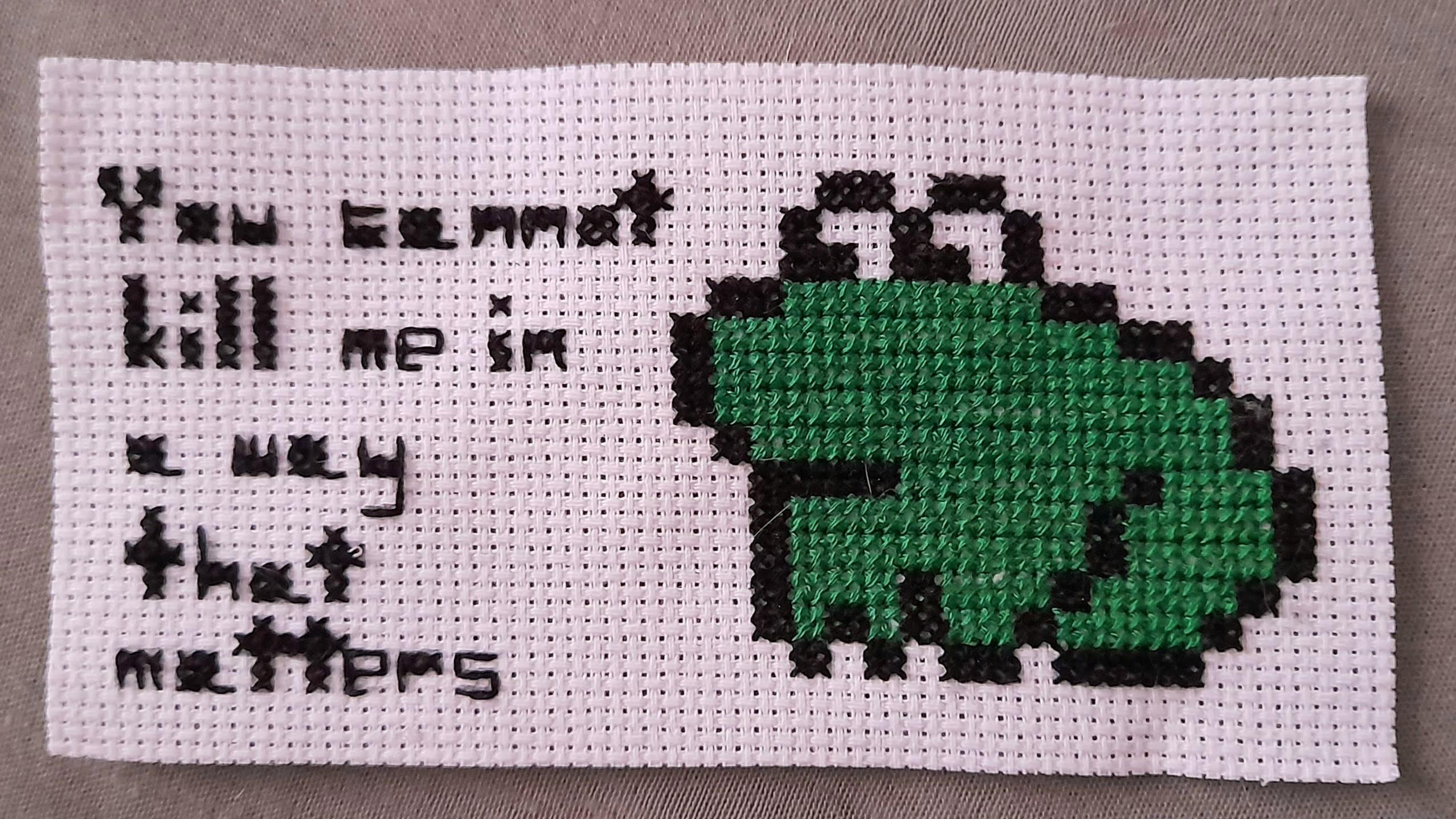 cross-stitch of a frog saying 'you cannot kill me in a way that matters'